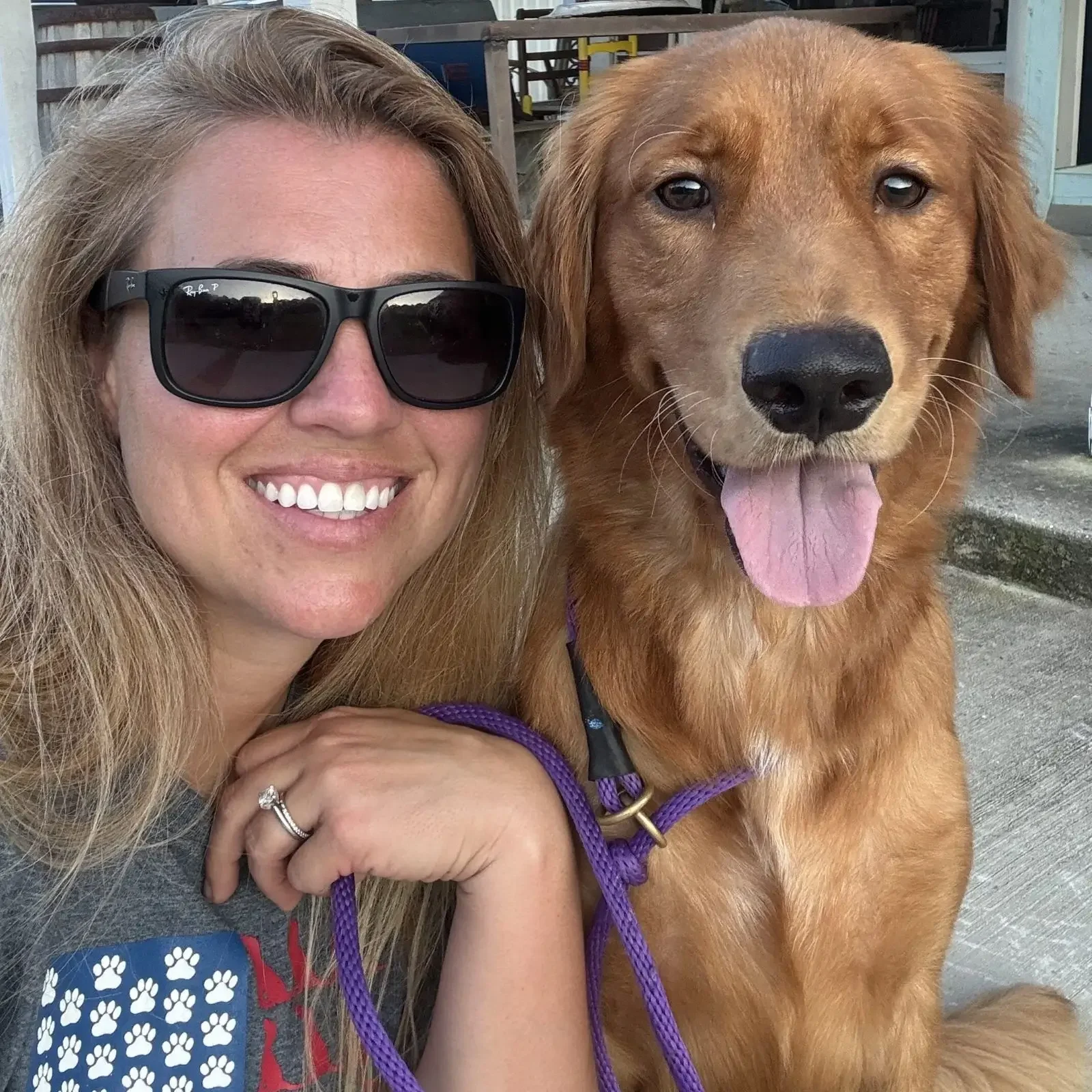 Smiling woman with dog wearing sunglasses.